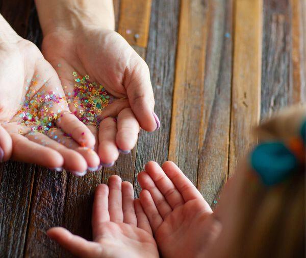 Woman holding star confetti to give to her daughter